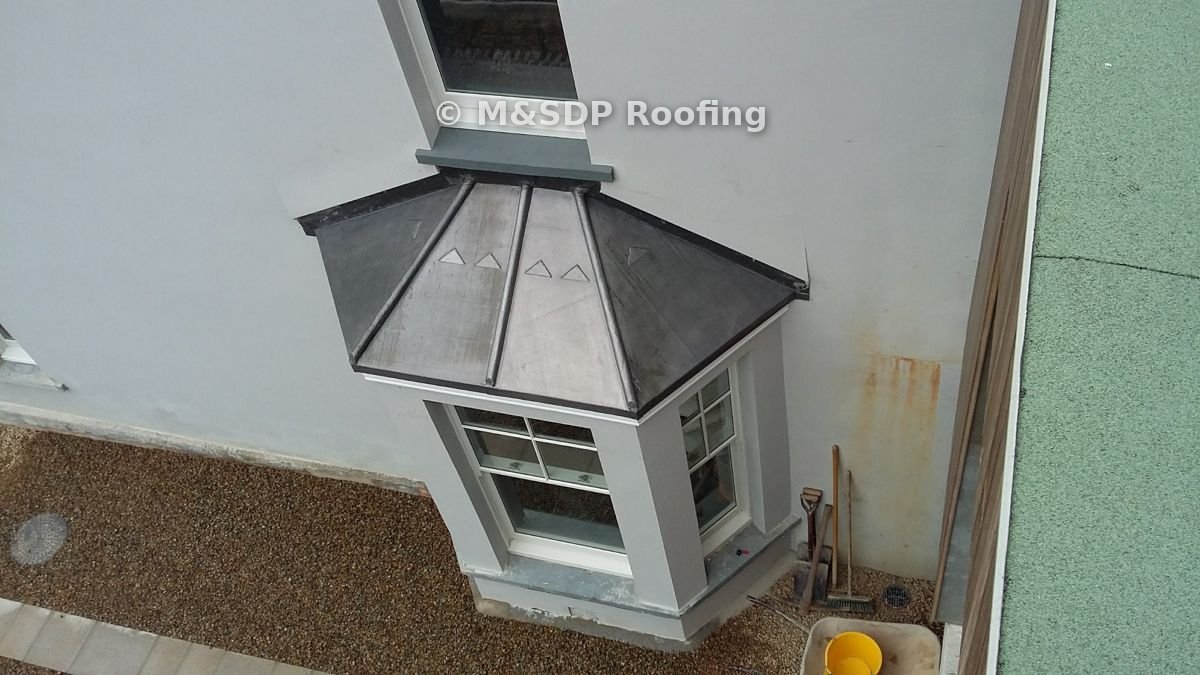 Hand-dressed lead bay window roof with wood-cored rolls