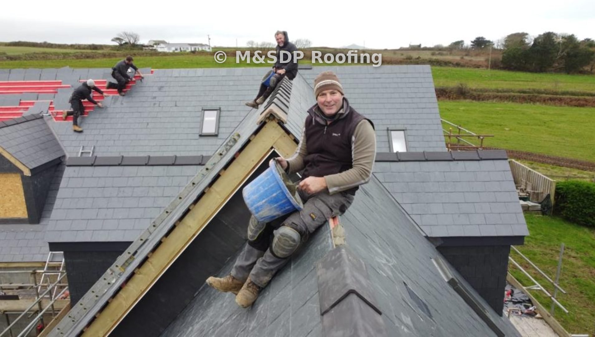 The roofing team bedding the ridge