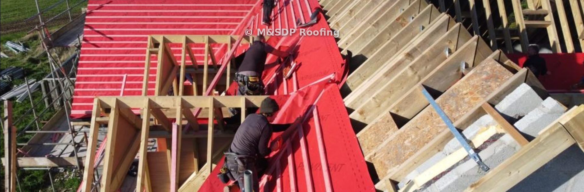 Roofers fixing membrane and battens around a dormer